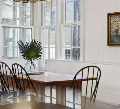 Gather around this beautiful dining table where natural light streams through windows, creating the perfect spot for your morning coffee or evening meals together.