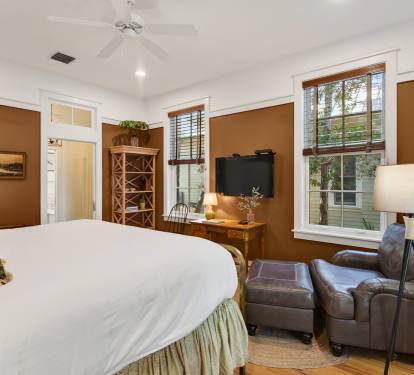 Unwind in your cozy bedroom with warm earth tones, leather seating, and natural light streaming through lovely windows.