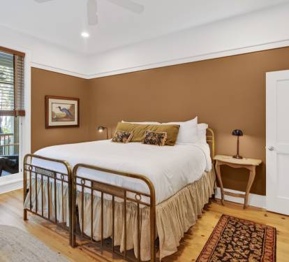 Sink into crisp white linens and let warm wood tones embrace you in this charming bedroom retreat.