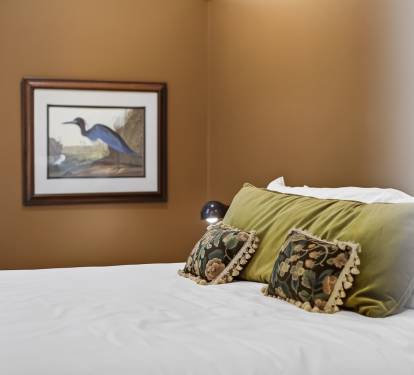 Sink into crisp white linens with decorative pillows that add warmth to your peaceful retreat.