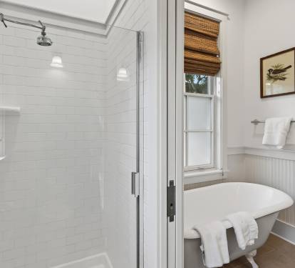Step into your pristine bathroom sanctuary with a rainfall shower, charming subway tiles, and natural light streaming through bamboo shades.