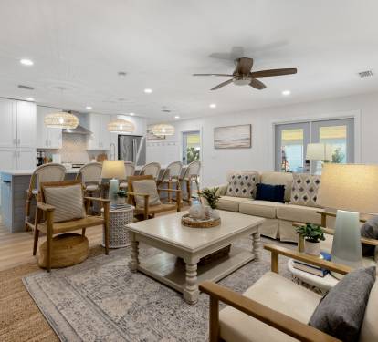Relax in your spacious open-plan living area with coastal-inspired decor, modern kitchen, and comfortable seating perfect for gathering with loved ones.