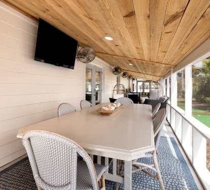 Gather around your private covered porch for meals under the warm wood ceiling, with garden views and entertainment ready for memorable moments.