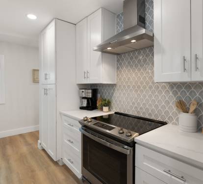 Step into your sleek modern kitchen featuring premium appliances, stunning geometric backsplash, and ample counter space for cooking memorable meals.
