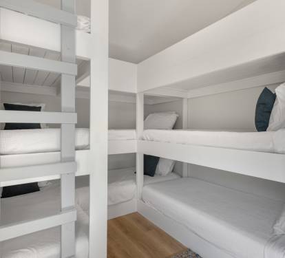 Sleep soundly in your cozy built-in bunk space with crisp white linens and thoughtful design details for comfort.