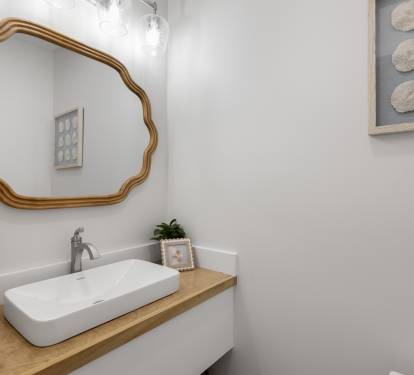 Fresh up in your stylish powder room with elegant gold mirror and coastal touches.