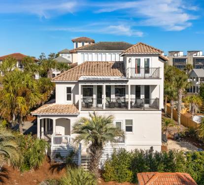 Stunning Mediterranean-style beachside villa surrounded by lush palms in an upscale coastal neighborhood.
