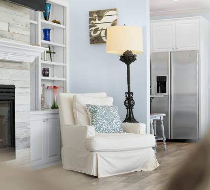 Curl up in your cozy reading chair beside the crackling fireplace, where coastal charm meets comfort in this beautifully designed living space.