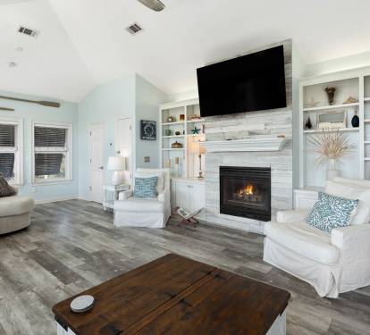 Sink into plush seating beside your crackling fireplace, where built-in shelving displays your treasures and soft lighting creates the perfect ambiance.