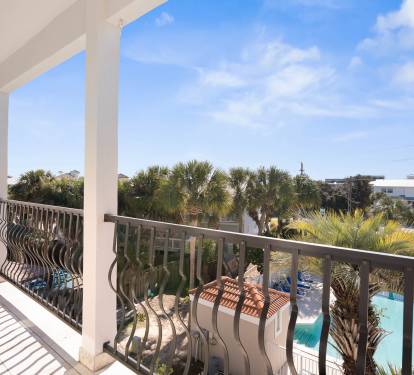 Relax on your private balcony overlooking tropical palms and the sparkling pool below on this perfect sunny day.