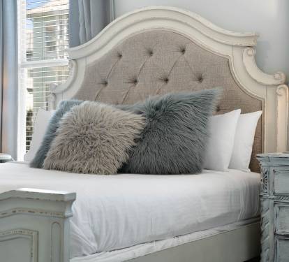 Sink into the plush linens and fluffy pillows of your elegantly appointed bedroom, where soft lighting creates the perfect ambiance for rest.