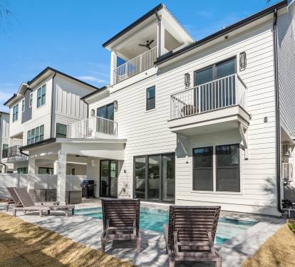 Modern multi-story vacation home with private pool, outdoor lounging area, and tropical landscaping in a peaceful neighborhood setting.