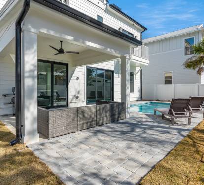 Your private covered patio features wicker seating and a sparkling pool, perfect for morning coffee or evening relaxation.