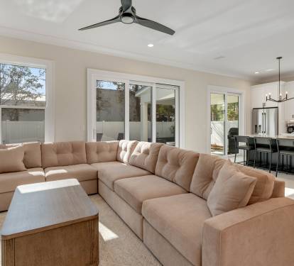 Relax in your spacious living room where plush sectional seating meets modern elegance, bathed in natural light from expansive windows.