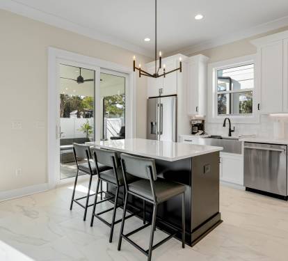 Your gourmet kitchen awaits with sleek white cabinetry, premium stainless appliances, and a spacious island perfect for morning coffee or evening gatherings.