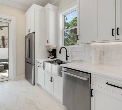 Your sleek modern kitchen features crisp white cabinetry, premium stainless steel appliances, and pristine countertops—perfect for preparing memorable meals during your stay.