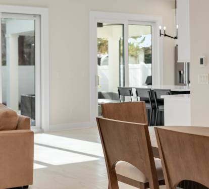 Relax in your bright, open living space where warm wood dining meets cozy seating, all flowing seamlessly to your private outdoor area.