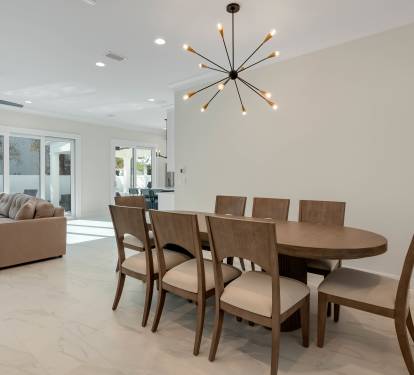 Gather around your elegant dining table for eight, bathed in natural light from floor-to-ceiling windows overlooking the patio.