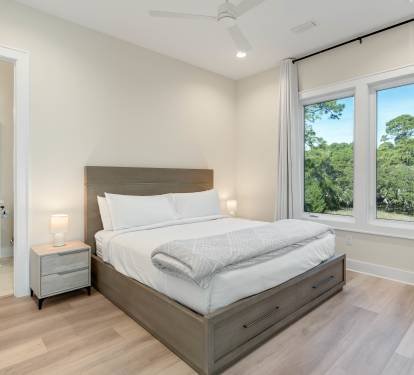 Wake up in your serene bedroom sanctuary with treetop views streaming through large windows, crisp linens awaiting your peaceful retreat.