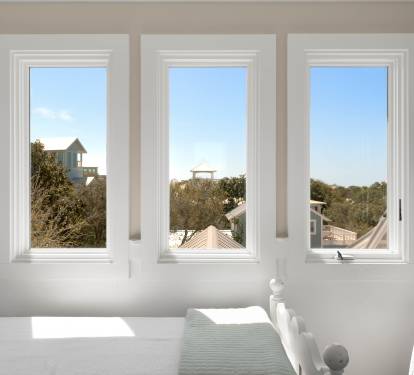 Wake up to peaceful mornings in your bright bedroom, where three picture windows frame leafy rooftops and blue skies.
