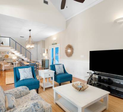 Relax in your stylish living room with vaulted ceilings, cozy blue chairs, and entertainment center for perfect evenings in.