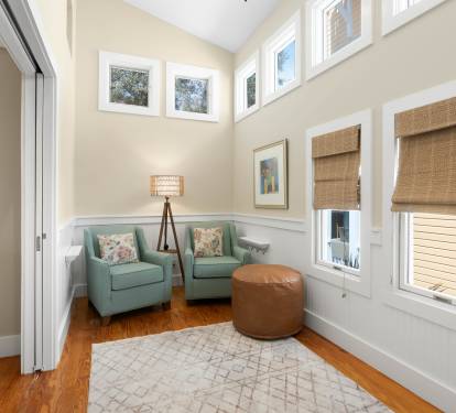 Sink into these plush chairs by the window, where natural light streams through bamboo shades and creates your perfect reading nook.