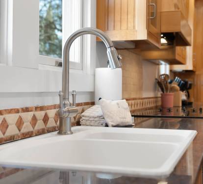 Your fully equipped kitchen features a pull-down faucet, quality appliances, and warm wood cabinetry—perfect for preparing memorable meals.