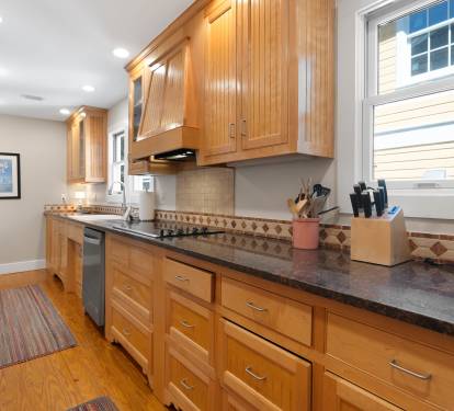 Prepare delicious meals in your spacious kitchen featuring warm wood cabinets, granite counters, and modern appliances.
