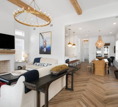 Unwind in this bright, open living space where coastal charm meets modern comfort with soaring ceilings and warm wood touches.