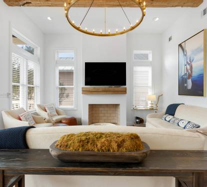 Unwind in your elegant living space with exposed beams, modern fireplace, and plush seating perfect for cozy evenings.