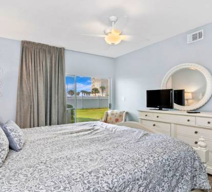 Drift off in your serene bedroom featuring soft blue walls, comfortable bedding, and peaceful garden views through your private window.
