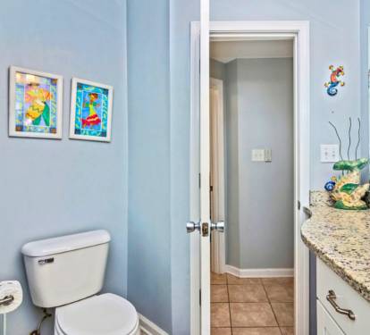 Brighten your morning routine in this cheerful bathroom featuring playful ocean-themed artwork and granite countertops with thoughtful touches throughout.