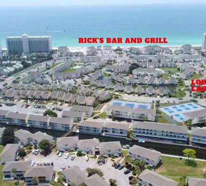 Aerial view showcasing the property's location near pristine beaches and local dining, with Rick's Bar and Grill nearby.