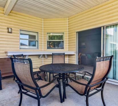 Your private covered patio offers comfortable outdoor dining with stylish furniture, perfect for morning coffee or evening meals.