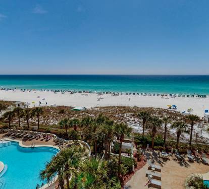 Beachfront property featuring pools and direct access to pristine white sand beach with turquoise waters.