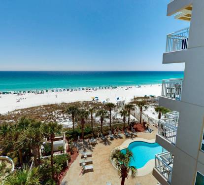 Beachfront property offers stunning views of white sand beaches and turquoise waters, with an outdoor pool and tropical landscaping.