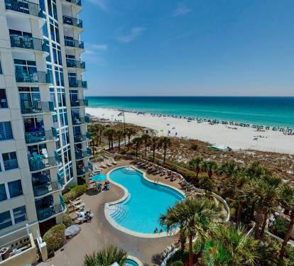 Beachfront resort offering stunning views of turquoise waters and white sandy beaches with pool and tropical landscaping.
