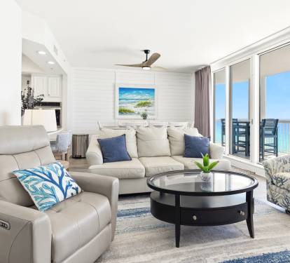 Relax in your bright living space with comfortable seating and stunning ocean views through floor-to-ceiling windows.