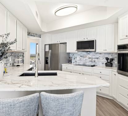 Your gourmet kitchen awaits with gleaming marble counters, premium appliances, and elegant white cabinetry—perfect for creating memorable meals during your stay.