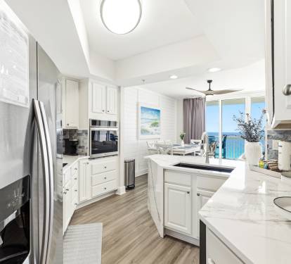 Cook with ocean views through your bright kitchen windows, featuring modern appliances and elegant marble countertops.