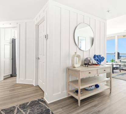 Step into your bright coastal retreat where ocean views greet you through floor-to-ceiling windows and coastal décor creates instant relaxation.