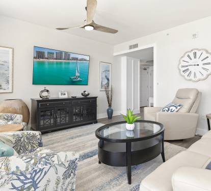 Relax in your coastal-themed living room with comfortable seating and entertainment center, perfect for unwinding after beach days.