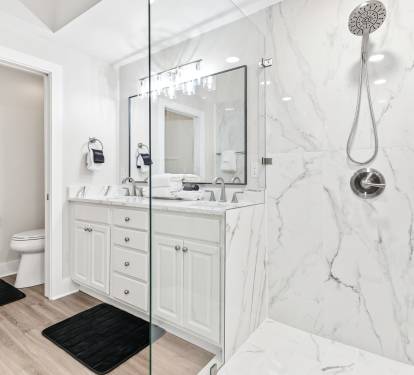 Step into your luxurious marble-adorned bathroom with sleek glass shower and dual vanities for ultimate comfort.
