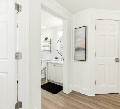 Step into your bright, welcoming hallway where crisp white doors lead to your private bathroom retreat.