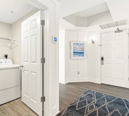 Step inside your welcoming entrance where coastal artwork and modern touches create instant comfort, with convenient in-unit laundry just steps away.