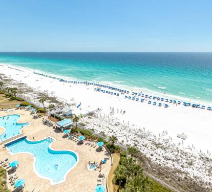 Stunning beachfront resort featuring expansive pools and pristine white sand beach with crystal-clear turquoise waters.