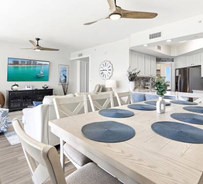 Your open-plan living space blends coastal charm with modern comfort, featuring a fully equipped kitchen and dining area perfect for memorable meals.