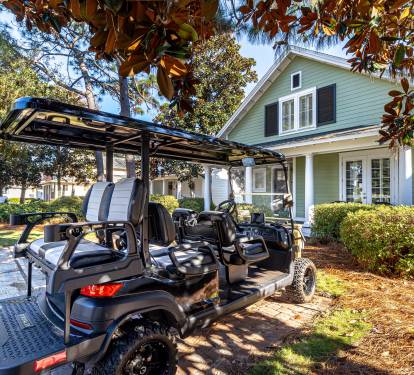 Charming mint green property with convenient golf cart access for easy exploration of the surrounding tree-lined neighborhood.