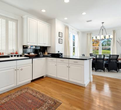 Cook your favorite meals in this bright, modern kitchen with white cabinets and dark countertops, then enjoy dining with lake views.