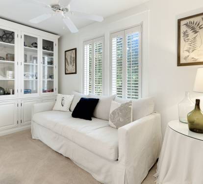 Relax in your bright living room where white built-in shelving and a cozy sofa create the perfect space for reading or unwinding.